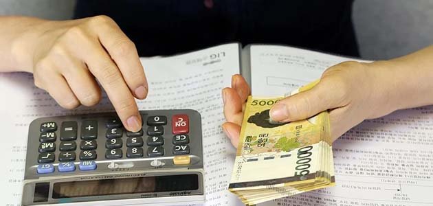آلة حاسبة وأموال تشير إلى قرارات مالية ونفقات