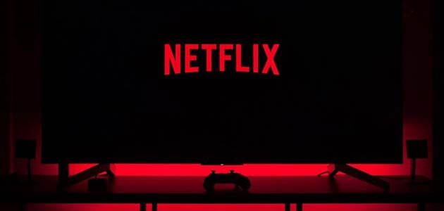 مكتوب عبارة نتفلكس "NETFLIX" بالإنجليزية على شاشة تلفزيون باللون الأحمر