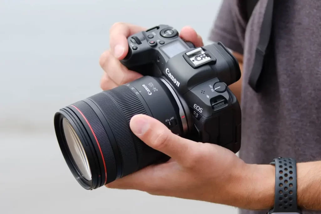 مصور يحمل كاميرا تصوير فوتوغرافي Canon EOS R5