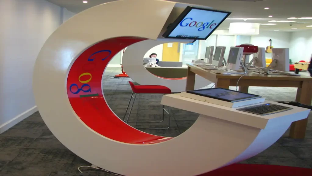 مقر شركة جوجل من الداخل يظهر مكاتب وشاشة مكتوب عليها عبارة Google